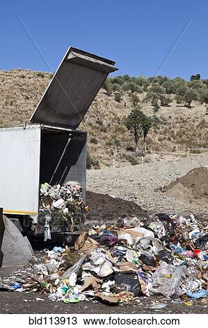 Stock Image - Truck dumping refuse into landfill. Fotosearch