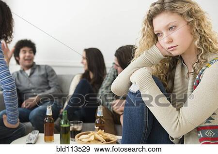 Woman sitting apart from friends View Large Photo Image Stock Photo - Woman sitting apart from friends. Fotosearch