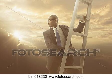 Stock Image - African American businessman climbing ladder. Fotosearch