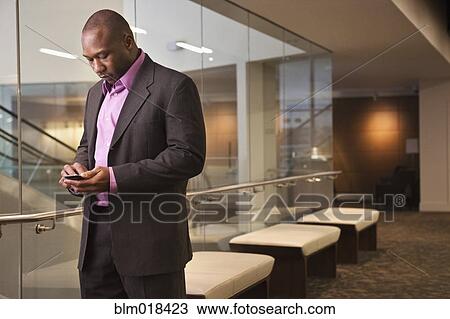 Stock Image - African American businessman using cell phone. Fotosearch