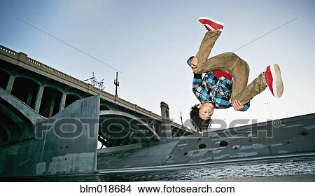 Asian man break dancing under overpass View Large Photo Image Picture - Asian man break dancing under overpass. Fotosearch