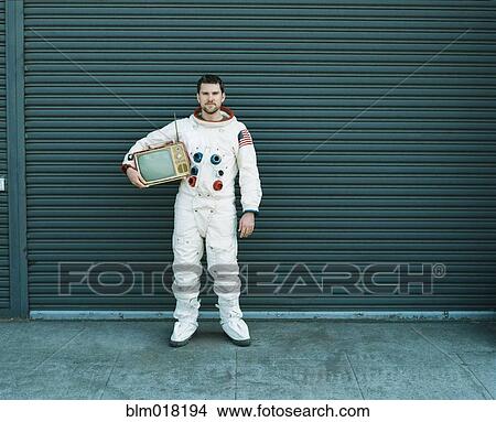 Picture - Astronaut carrying television on city street. Fotosearch