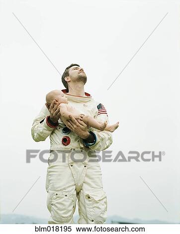 Stock Photography - Astronaut holding baby outdoors. Fotosearch
