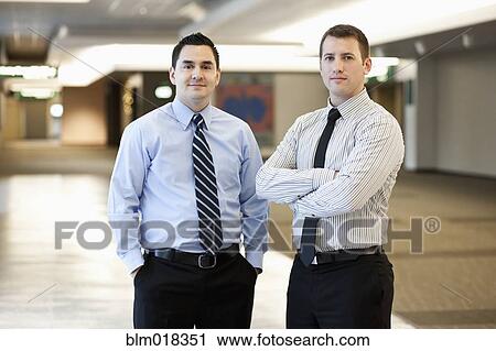 Stock Image - Businessman standing together in office. Fotosearch