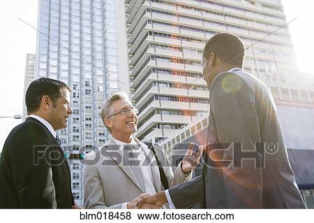 Businessmen shaking hands on city street View Large Photo Image Stock Photo - Businessmen shaking hands on city street. Fotosearch