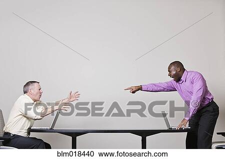 Stock Image - Businessmen shouting across table. Fotosearch