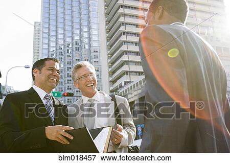 Stock Photo - Businessmen talking on city street. Fotosearch