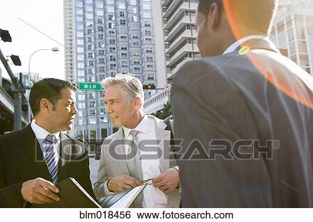 Businessmen talking on city street View Large Photo Image Stock Photograph - Businessmen talking on city street. Fotosearch