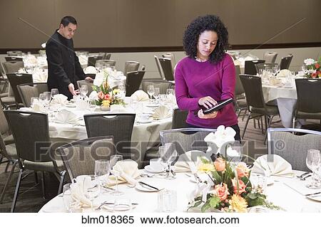 Stock Photography - Businesswoman using tablet computer in dining room. Fotosearch