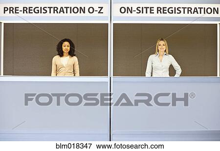 Businesswomen smiling in registration booths View Large Photo Image Stock Photo - Businesswomen smiling in registration booths. Fotosearch
