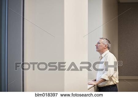 Caucasian businessman looking out window View Large Photo Image Stock Photo - Caucasian businessman looking out window. Fotosearch
