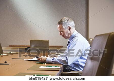 Caucasian businessman working at meeting table View Large Photo Image Stock Photo - Caucasian businessman working at meeting table. Fotosearch