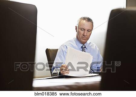 Stock Photography - Caucasian businessman working at meeting table. Fotosearch