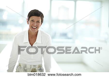 Stock Image - Caucasian businesswoman smiling in office. Fotosearch