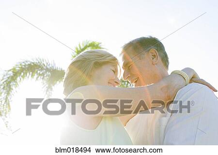 Picture - Caucasian couple hugging outdoors. Fotosearch