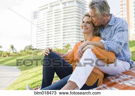 Stock Image - Caucasian couple relaxing in city park. Fotosearch