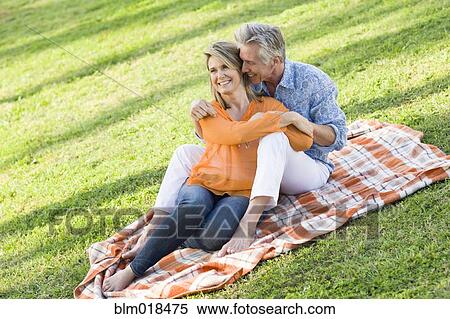 Caucasian couple relaxing in grass View Large Photo Image Stock Photography - Caucasian couple relaxing in grass. Fotosearch
