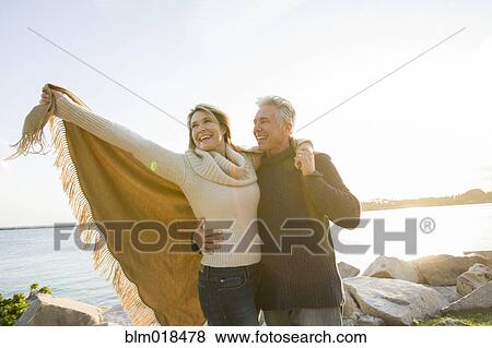 Stock Photo - Caucasian couple walking by lake. Fotosearch