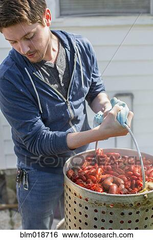 Stock Photograph - Caucasian man cooking crawfish outdoors. Fotosearch
