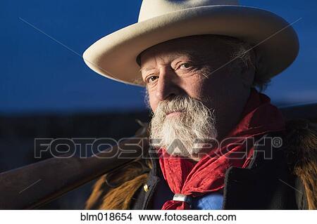 Picture - Caucasian man holding gun outdoors. Fotosearch