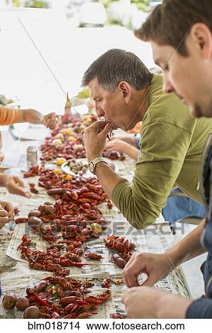 Caucasian men eating at crawfish boil View Large Photo Image Picture - Caucasian men eating at crawfish boil. Fotosearch