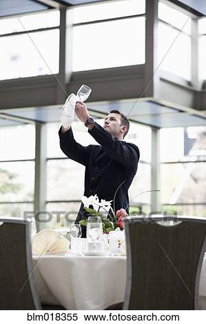 Caucasian waiter setting tables in dining room View Large Photo Image Stock Photography - Caucasian waiter setting tables in dining room. Fotosearch