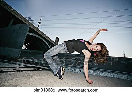 Stock Photography - Caucasian woman break dancing under overpass. Fotosearch