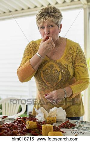 Stock Photography - Caucasian woman eating at crawfish boil. Fotosearch
