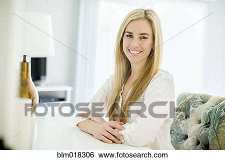 Stock Photograph - Caucasian woman smiling at desk. Fotosearch