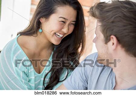 Couple laughing together outdoors View Large Photo Image Stock Photograph - Couple laughing together outdoors. Fotosearch