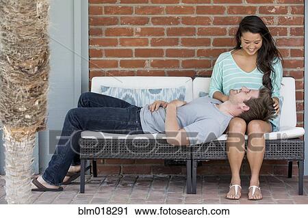Couple relaxing together on bench View Large Photo Image Stock Image - Couple relaxing together on bench. Fotosearch