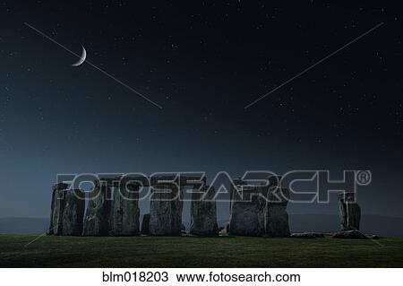Stock Image - Crescent moon over Stonehenge monument, Wiltshire, United Kingdom. Fotosearch