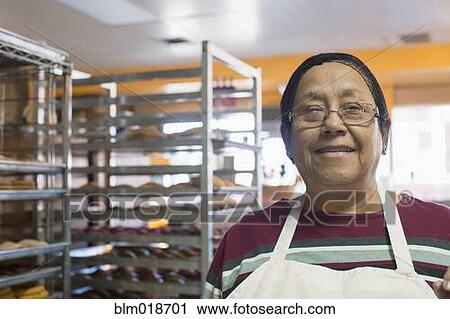 Stock Image - Hispanic baker smiling in kitchen. Fotosearch