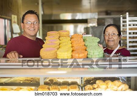 Hispanic bakers smiling in kitchen View Large Photo Image Stock Image - Hispanic bakers smiling in kitchen. Fotosearch
