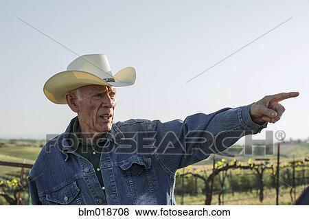 Hispanic farmer pointing in vineyard View Large Photo Image Stock Photo - Hispanic farmer pointing in vineyard. Fotosearch