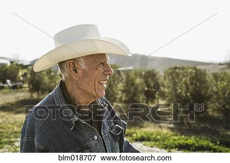 Stock Photo - Hispanic farmer smiling in vineyard. Fotosearch