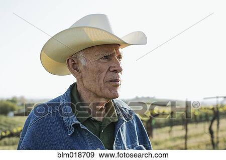 Stock Photo - Hispanic farmer standing in vineyard. Fotosearch
