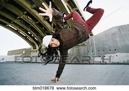 Stock Photo - Hispanic woman break dancing under overpass. Fotosearch