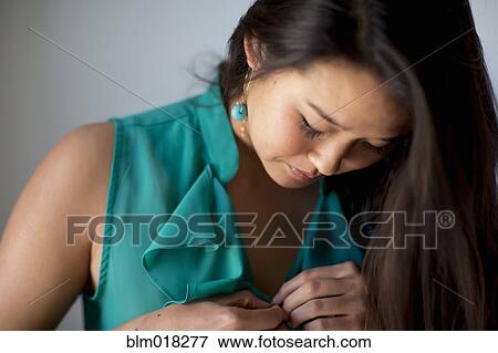 Japanese woman buttoning her blouse View Large Photo Image Stock Photo - Japanese woman buttoning her blouse. Fotosearch