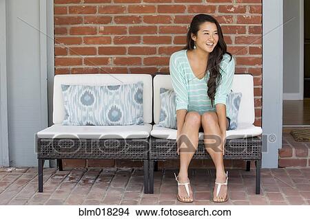 Picture - Japanese woman sitting on bench. Fotosearch