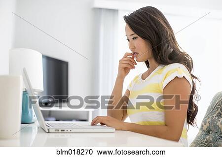Stock Image - Japanese woman using laptop. Fotosearch