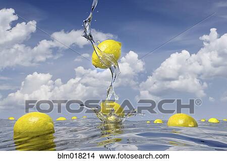 Picture - Lemons splashing into pool of water. Fotosearch