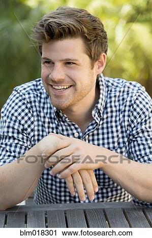 Stock Image - Man sitting outdoors. Fotosearch