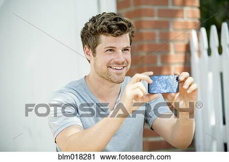 Man using cell phone outdoors View Large Photo Image Stock Image - Man using cell phone outdoors. Fotosearch