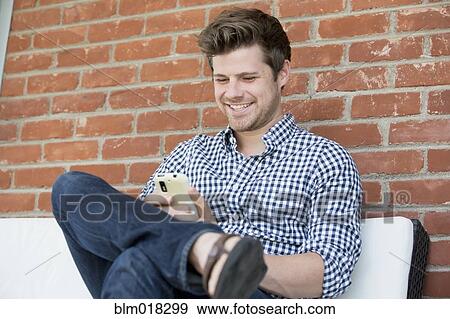Man using cell phone outdoors View Large Photo Image Stock Photo - Man using cell phone outdoors. Fotosearch