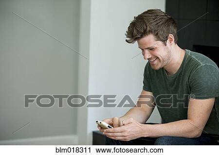 Stock Image - Man using cell phone. Fotosearch