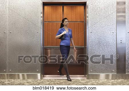 Mixed race businesswoman in elevator View Large Photo Image Stock Photo - Mixed race businesswoman in elevator. Fotosearch