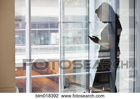 Stock Image - Mixed race businesswoman using cell phone. Fotosearch