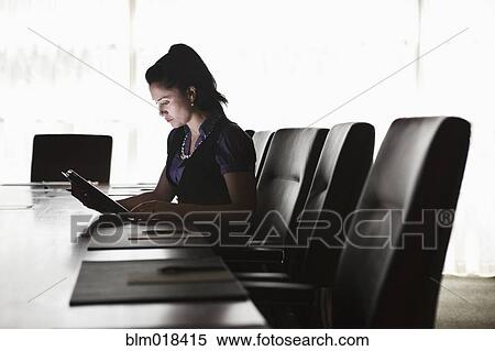 Stock Photography - Mixed race businesswoman using tablet computer. Fotosearch