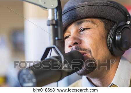 Mixed race disc jockey talking into mic in studio View Large Photo Image Stock Photo - Mixed race disc jockey talking into mic in studio. Fotosearch